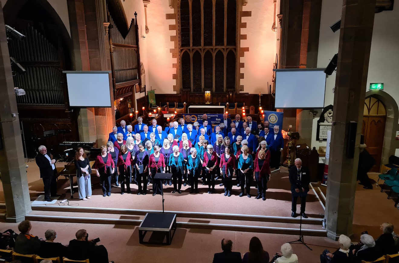 Gledholt Male Voice Choir in their blue blazer in church with a women's Choir stood in front of them