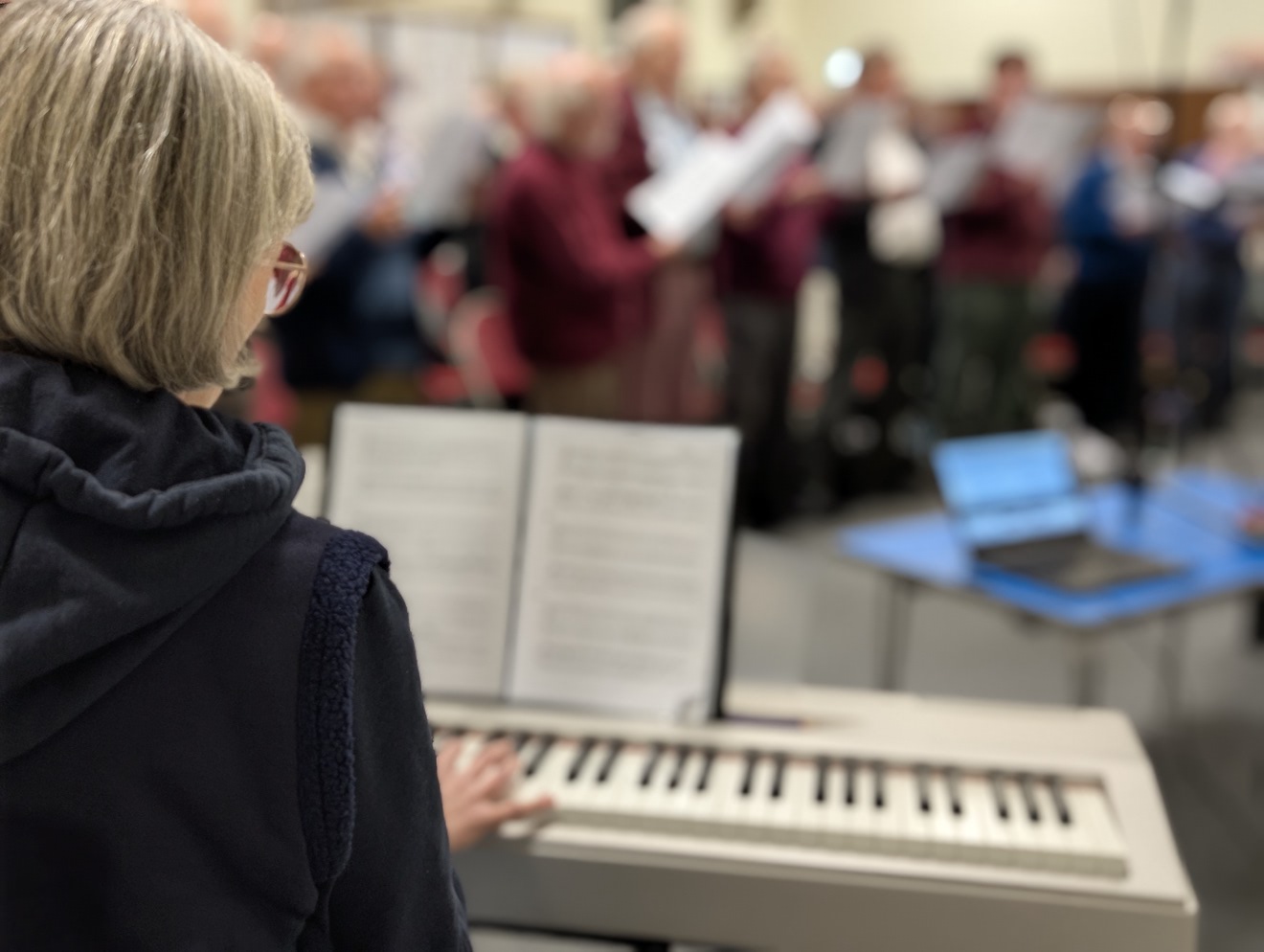 61:Choir rehearsal. The photo is a close up from behind the Accompanist.